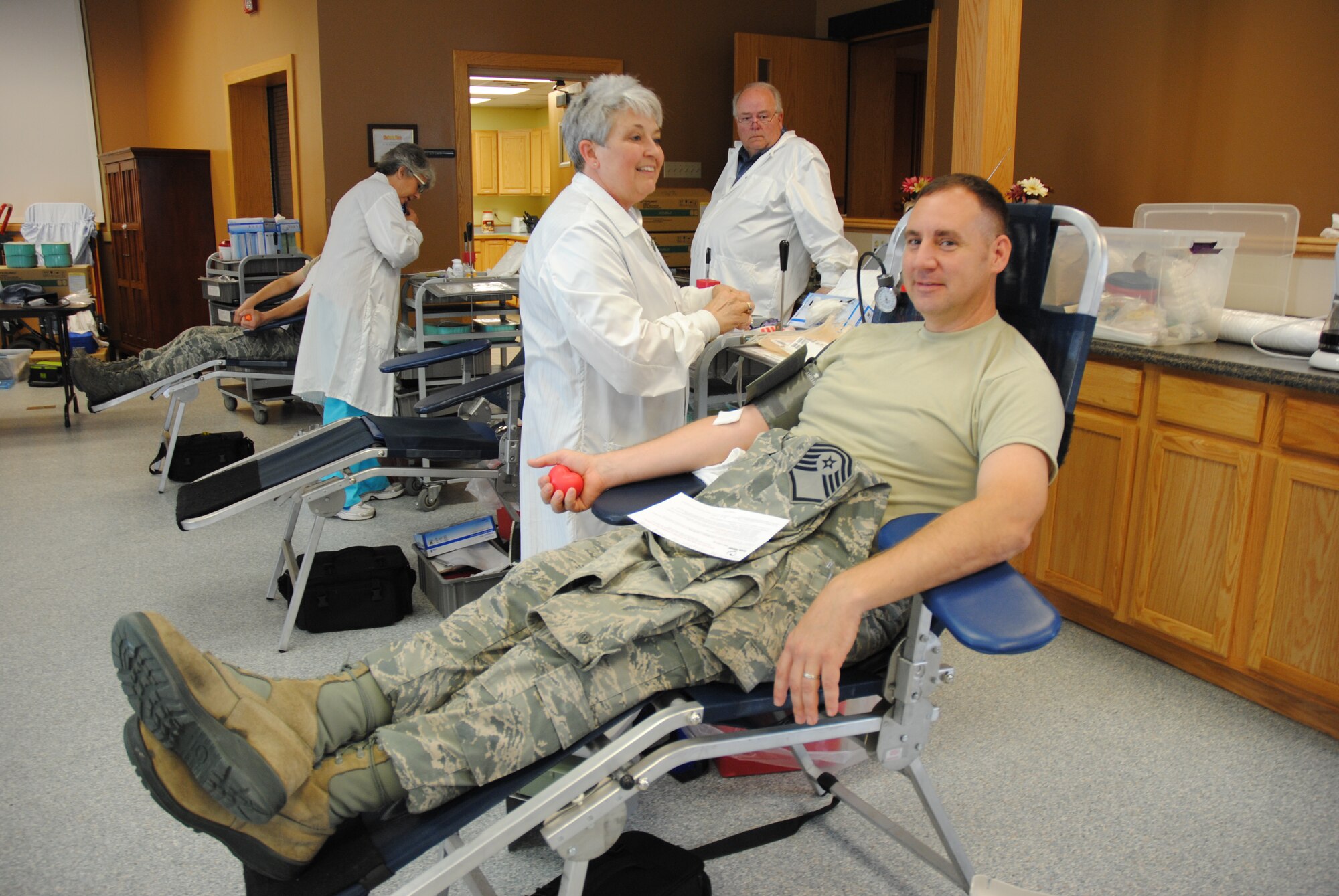 Deb Schue, DAK-MINN Blood Bank donor center supervisor, preps Master Sgt. David Evans, for a blood donation during a blood drive held Aug. 6, 2014, at Sven's Den on Grand Forks Air Force Base, N.D. Evans is a regular blood donor. He began donating blood since he first joined the military in 1996.  Evans was one of nine members from the 319th Communications Squadron to donate blood. (U.S. Air Force photo/Staff Sgt. Luis Loza Gutierrez)