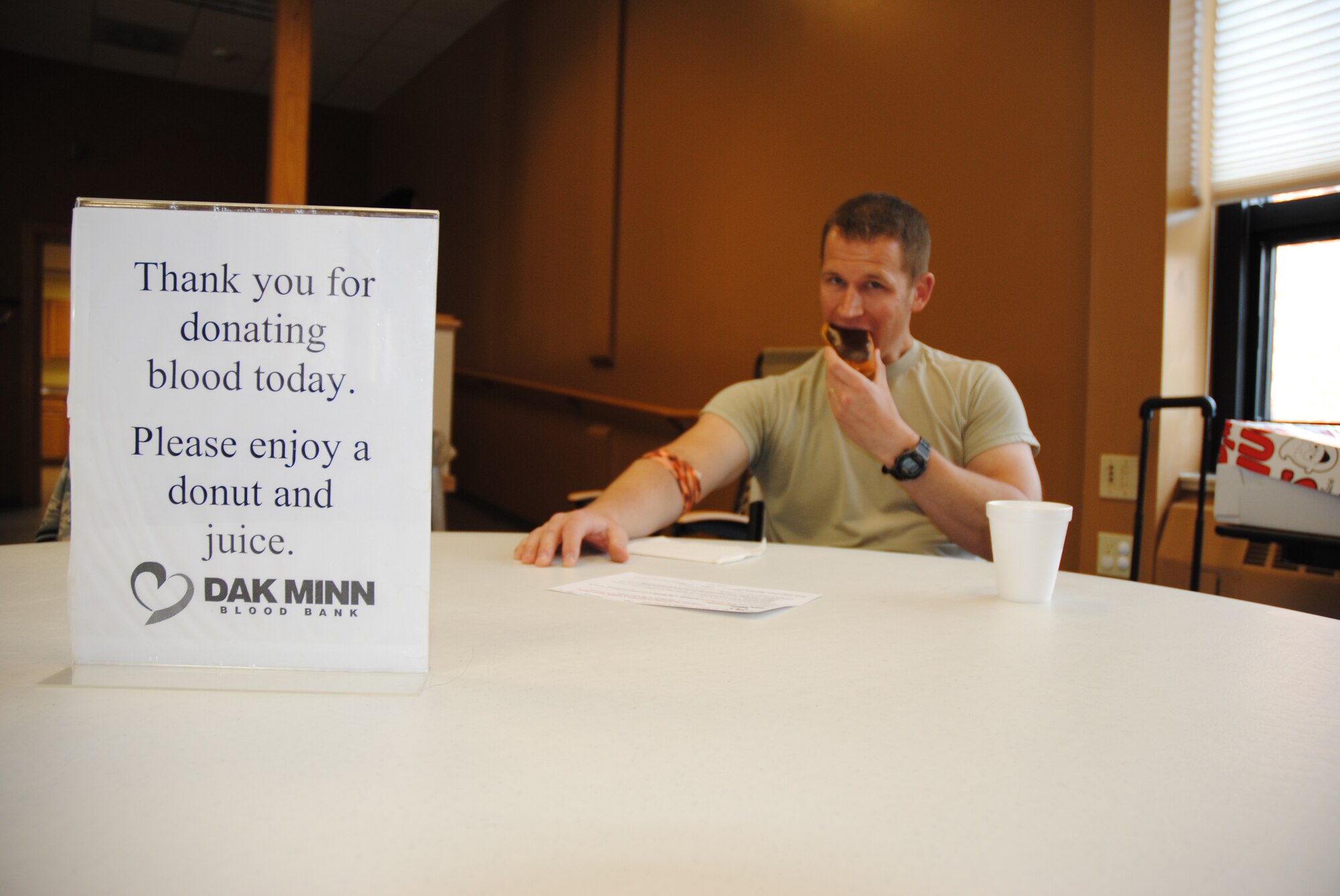 Staff Sgt. James Madnick enjoys a pastry after making a donation during a blood drive on Aug. 6, 2014, at Sven's Den on Grand Forks Air Force Base, N.D.  Pastries and juice, which are rich in sugar help raise blood sugar-levels after a blood donation, which medical experts say help blood donors lessen the chances of experiencing symptoms such as fatigue, drowsiness or dizziness.  A hearty meal, especially one rich in iron along with plenty of water is also recommended before making a blood donation. (U.S. Air Force photo/Staff Sgt. Luis Loza Gutierrez)