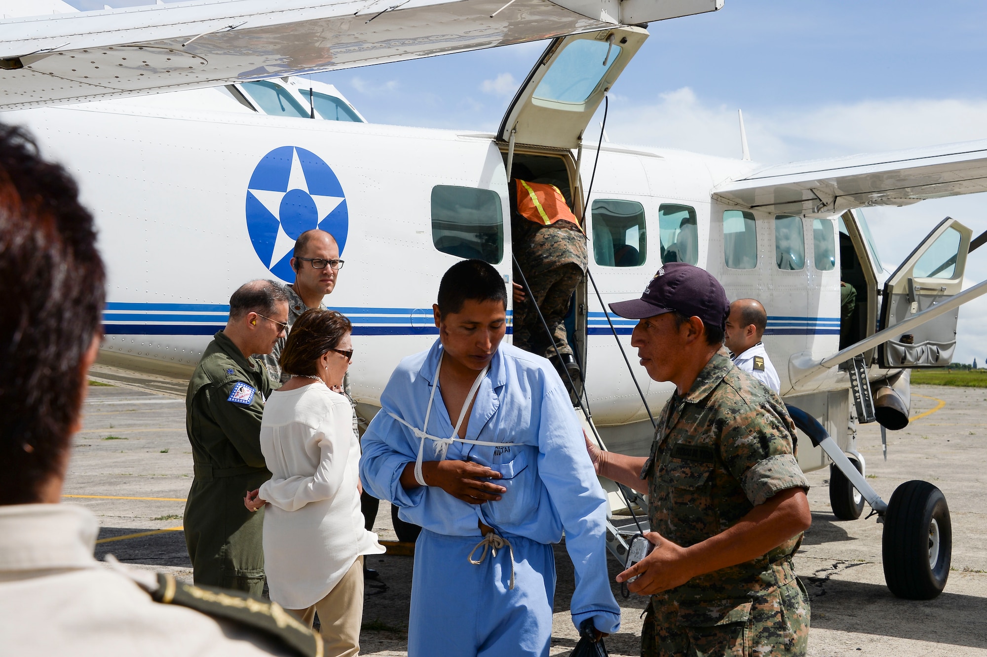 A Guatemalan service member is escorted off a plane by a member of the Guatemalan air force during an air medical transportation mission in Guatemala City, Guatemala, Aug. 6, 2014.  Six people were injured in a vehicle accident and were transported from a field clinic to Guatemala City for further medical care, during a medical subject matter expert exchange with the Guatemalan military.  The event gave U.S. forces the opportunity to observe the Guatemalan air force’s medical professions during a real time event.  (U.S. Air Force photo by Tech. Sgt. Heather R. Redman/Released)