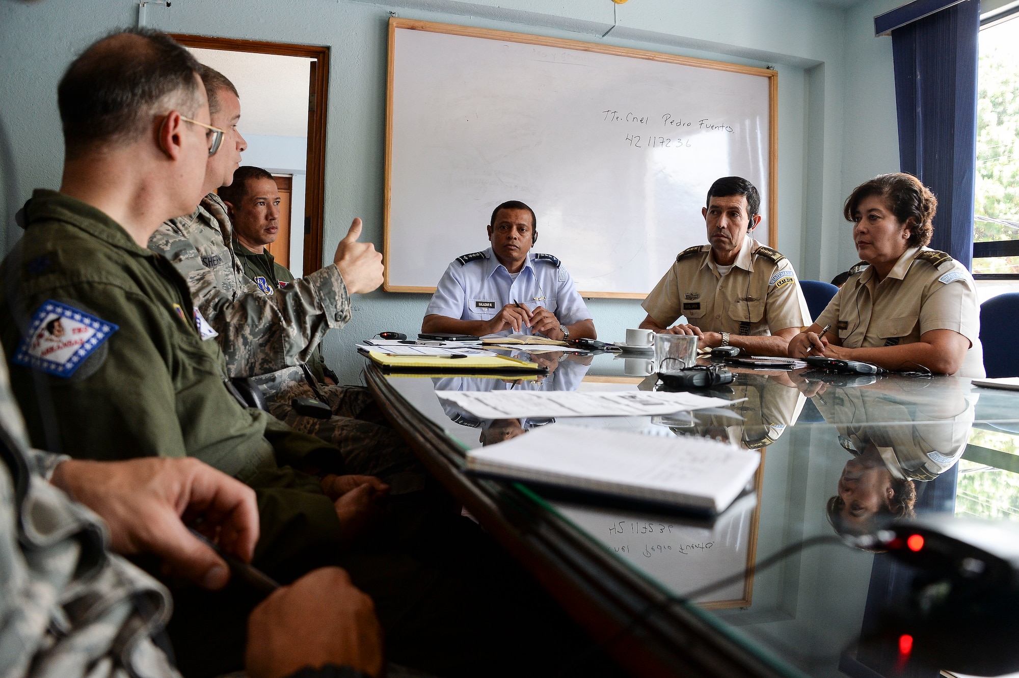 Lt. Cols. Eric Burdge and Paul Sherman along with Maj. Michael Kittell, assigned to Arkansas Air National Guard, discuss the goals for a subject matter expert exchange with the Guatemalan Military in Guatemala City, Guatemala, Aug. 4, 2014. Goals focused on educating the Guatemalan air force on individual readiness and establishing standards for flight medicine. (U.S. Air Force photo by Tech. Sgt. Heather R. Redman/Released)