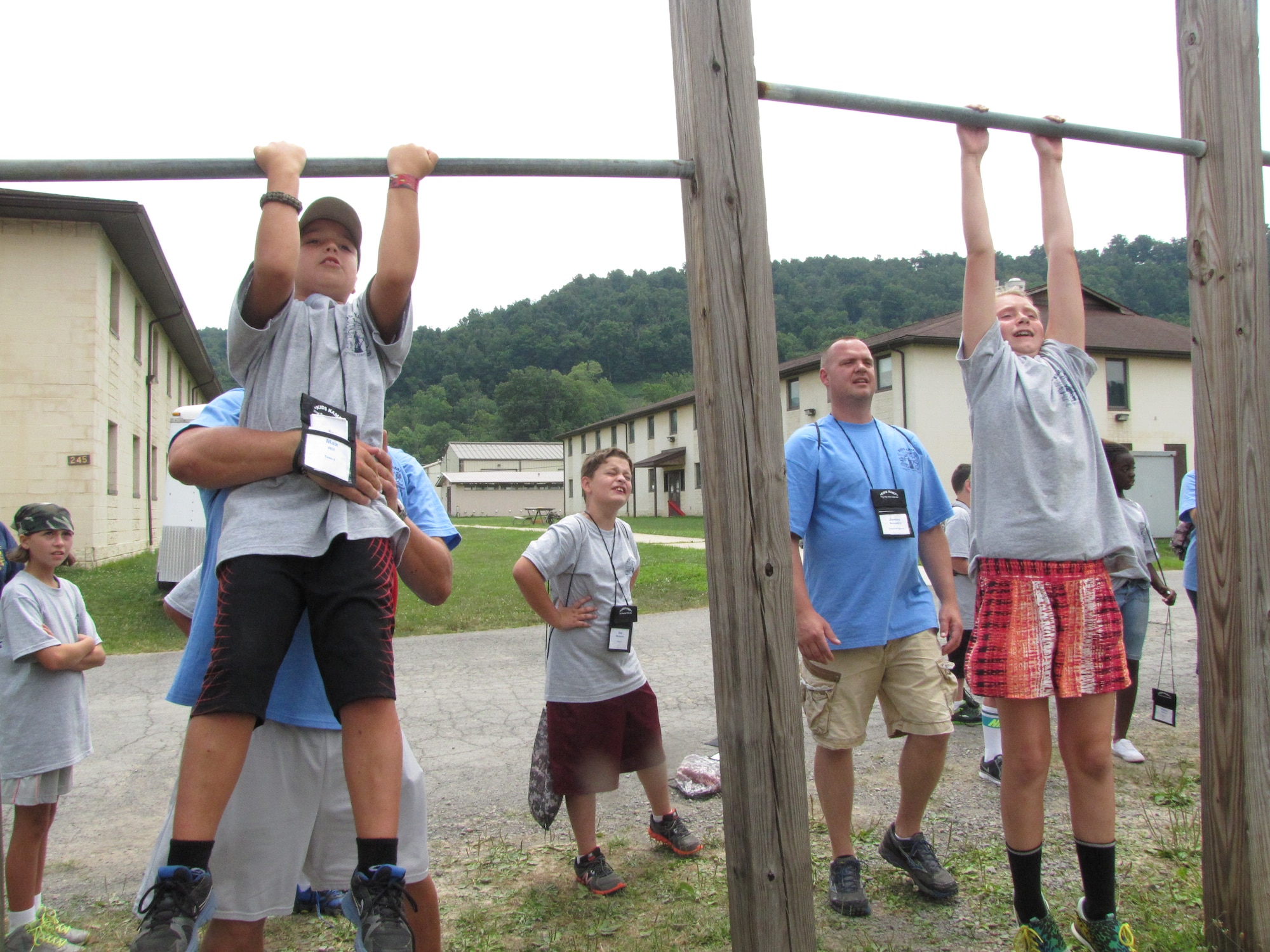 Volunteer counselors help campers perform proper military pull-ups at the 24th Annual West Virginia National Guard Military Kids Kamp. The camp is open
to children of West Virginia National Guard members between the ages of 9 and 14. (Air National Guard photo courtesy of Sherry Lewis.)