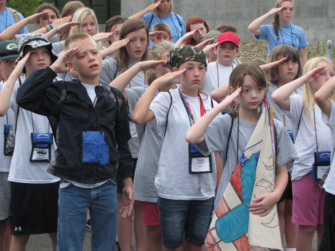 Campers at the West Virginia National Guard Kids Kamp salute the flag during a ceremony at Camp Dawson, W. Va.. The camp, which was held July 12-17, celebrated its 24th year of educating military children. The program began in 1991 as a way to help children of Guardsman, who were deployed in support of Operation Desert Storm, better understand the military. (Air National Guard photo courtesy of Sherry Lewis)