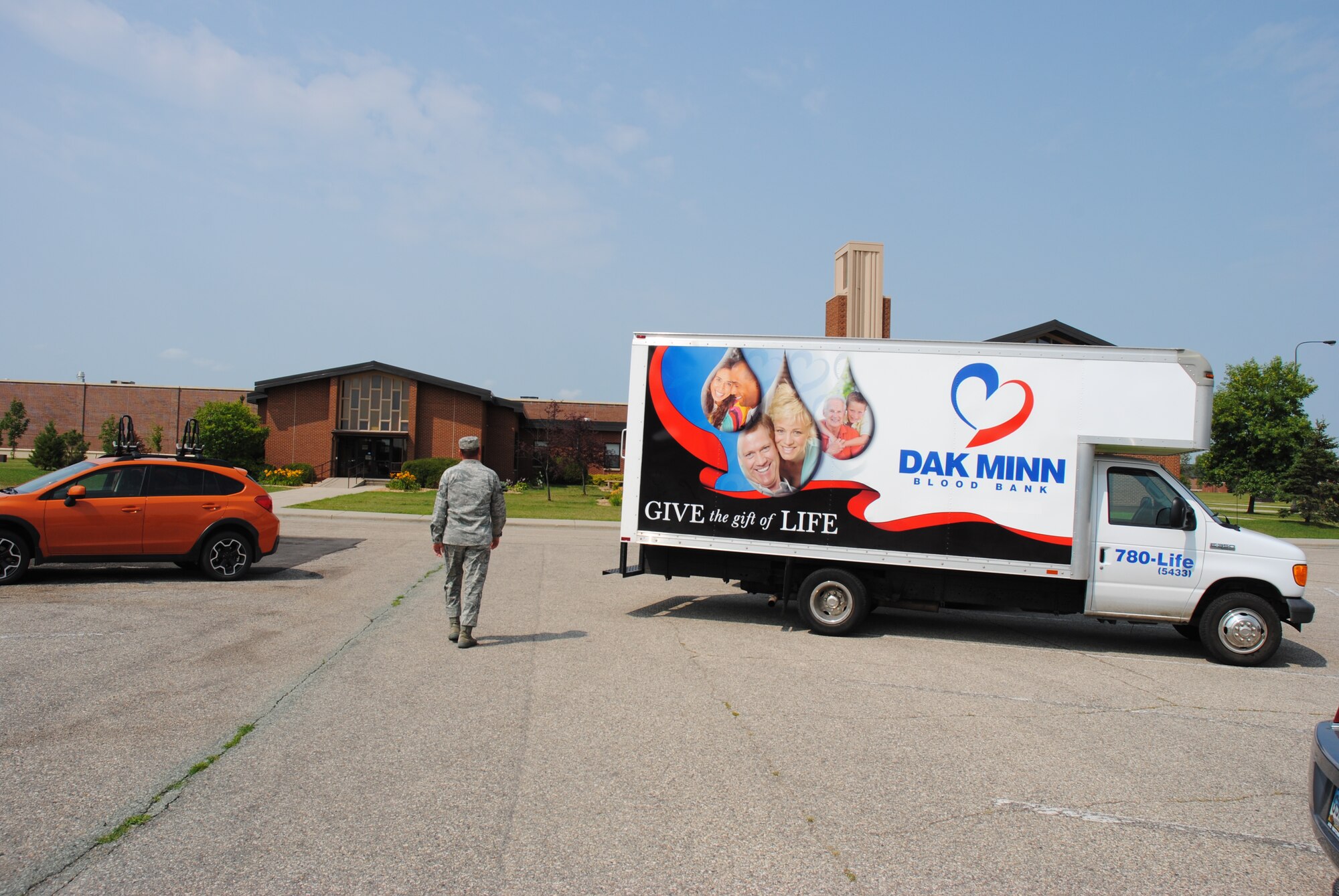 Staff Sgt. Thomas Sullivan, 319th Medical Support Squadron, walks past a DAK-MINN Blood Bank truck heads to Sven's Den to make a blood donation Aug. 6, 2014. Sullivan helped coordinate the recent blood drive. The 319th Medical Group partnered with DAK-MINN Blood Bank to help local hospital patients in need by hosting a blood drive on Grand Forks Air Force Base, N.D. (U.S. Air Force photo/Staff Sgt. Luis Loza Gutierrez)