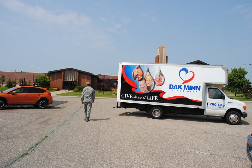 Staff Sgt. Thomas Sullivan, 319th Medical Support Squadron, walks past a DAK-MINN Blood Bank truck heads to Sven's Den to make a blood donation Aug. 6, 2014. Sullivan helped coordinate the recent blood drive. The 319th Medical Group partnered with DAK-MINN Blood Bank to help local hospital patients in need by hosting a blood drive on Grand Forks Air Force Base, N.D. (U.S. Air Force photo/Staff Sgt. Luis Loza Gutierrez)
