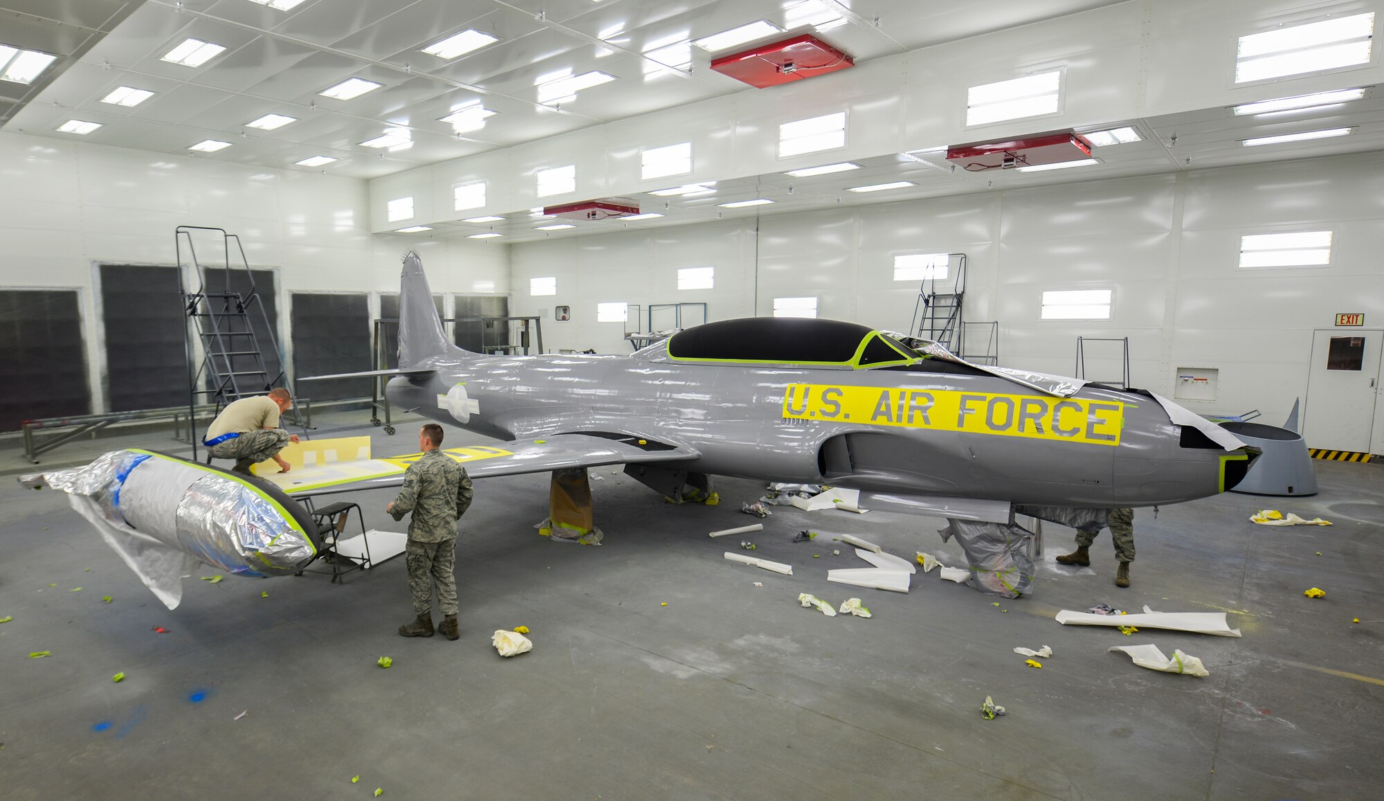 23d Equipment Maintenance Squadron Airmen apply stencils to a T-33 Shooting Star before repainting and returning it to the President George W. Bush Air Park at Moody Air Force Base Ga., July 30, 2014. The Airmen painted the aircraft in a Vanguard scheme, reflecting its ties to the 76th Fighter Squadron, a reserve unit here. (U.S. Air Force photo by Airman 1st Class Sandra Marrero/Released)
