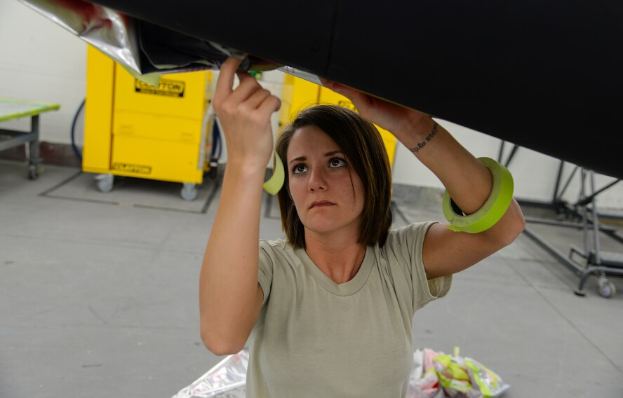 U.S. Air Force Airman 1st Class Allison Gran, 23d Equipment Maintenance Squadron aircraft structural maintenance apprentice, stencils a T-33 Shooting Star at Moody Air Force Base, Ga., July 30, 2014. Airmen moved the aircraft from the President George W. Bush Air Park and repainted it to reflect its history with the 76th Fighter Squadron. (U.S. Air Force photo by Airman 1st Class Sandra Marrero/Released)

