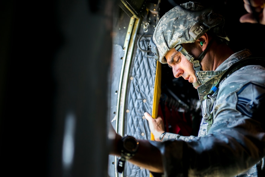 U.S. Air Force Master Sgt. David Edwards, 822nd Base Defense Squadron jumpmaster, conducts pre-jump checks over Tifton, Ga., Aug. 7, 2014. To ensure the safety of each jumper, Edwards confirmed the passenger door was locked in place and that nothing would impede the jumpers’ static-line control. (U.S. Air Force photo by Airman 1st Class Ryan Callaghan/Released)