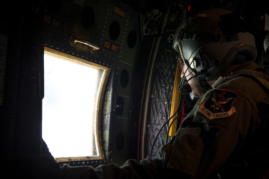 U.S. Air Force Senior Airman Edgar Perez, 71st Rescue Squadron loadmaster, looks out of the window of an HC-130P Combat King over the skies of Tifton, Ga., Aug. 7, 2014. The loadmaster is responsible for relaying flight path information and safety precautions to the jumpers, as well as ensuring all the passengers are secure prior to the jump. (U.S. Air Force photo by Airman 1st Class Ryan Callaghan/Released)