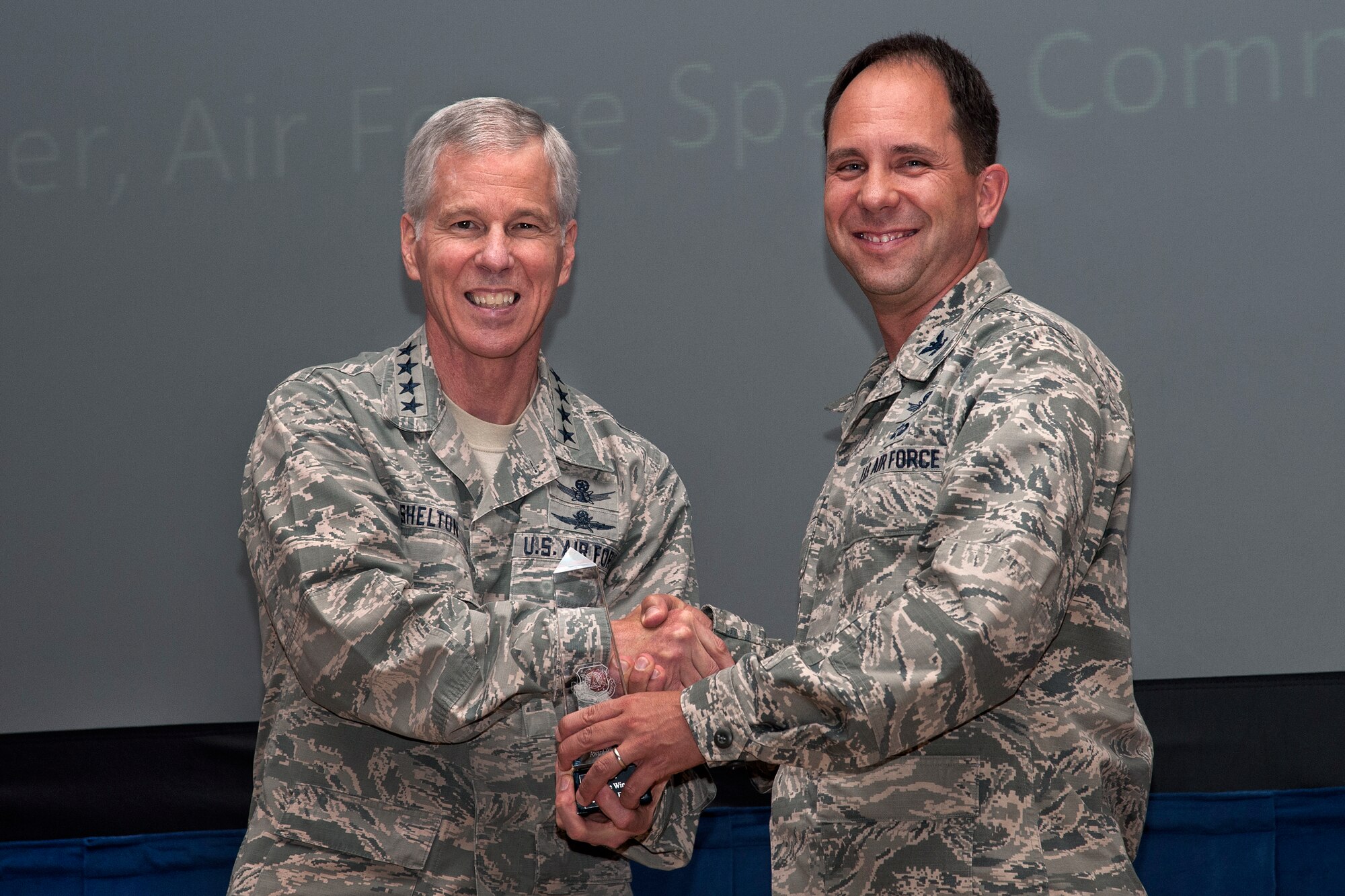 PETERSON AIR FORCE BASE, Colo. – General William L. Shelton (left), Air Force Space Command commander, presents the 2013 General Thomas S. Moorman Jr. Award to Col. John E. Shaw, 21st Space Wing commander, Aug. 4 at the 21 SW commander’s call. The award recognizes Air Force Space Command's best operational wing. (U.S. Air Force photo/Craig Denton)