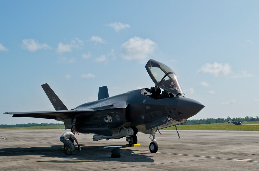 A 33rd Fighter Wing pilot exits an F-35A Lightning II as a 919th Special Operations Wing C-145 begins a take-off roll at Duke Field, Fla., Aug. 6.  The joint strike fighter’s first visit to the reserve base was to participate in a joint major accident response exercise between the 33rd FW, 919th SOW and the 96th Test Wing.  (U.S. Air Force photo/Tech. Sgt. Sam King)