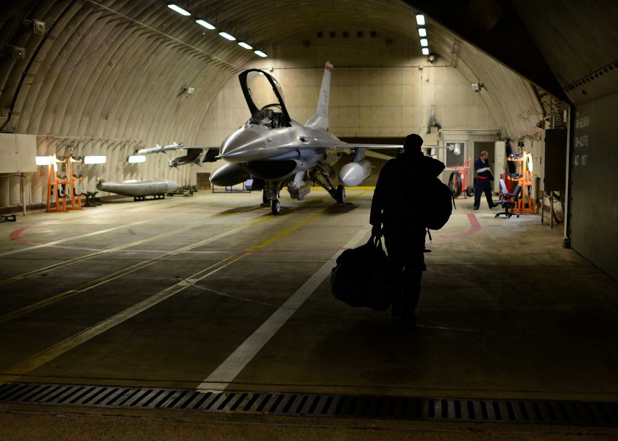 U.S. Air Force Capt. Taylor Blevins, a U.S. Air Force F-16 Fighting Falcon fighter aircraft pilot from the 480th Fighter Squadron at Spangdahlem Air Base, Germany, walks toward his jet in a hardened aircraft shelter Aug. 8, 2014, before leaving for a training event in Souda Bay, Greece, Aug. 11-23. Nearly 20 aircraft from Spangdahlem are participating in this training event, which aims to maintain regional peace and stability throughout Europe. (U.S. Air Force photo by Staff Sgt. Daryl Knee/Released)