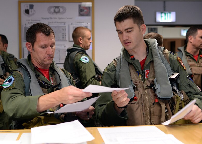 Two U.S. Air Force F-16 Fighting Falcon fighter aircraft pilots from the 480th Fighter Squadron at Spangdahlem Air Base, Germany, review their flight information before departing for a training event in Souda Bay, Greece, Aug. 11-23. The two nations' pilots will fly together in large-force training events, which are aimed at strengthening the compatibility between the U.S and Greece. (U.S. Air Force photo by Staff Sgt. Daryl Knee/Released)