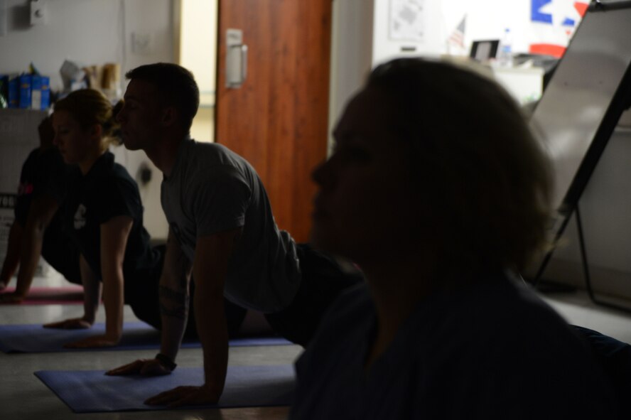 U.S. Soldiers and Airmen assigned to the Craig Joint Theater Hospital perform the cobra pose during a yoga session in the waiting area of flight medicine June 24, 2014. Hospital staff members sometimes attend the yoga class to get away from the stresses of working in one of the busiest hospitals in Afghanistan. (U.S. Air Force photo by Master Sgt. Cohen A. Young/Released)