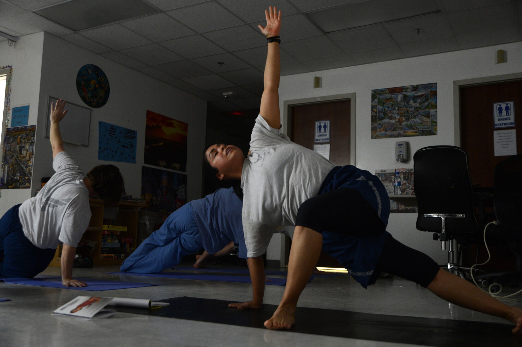 U.S. Air Force Senior Airman Kandie Ibarra, a lab technician assigned to the 455th Expeditionary Medical Group, leads co-workers in the triangle pose during a yoga class June 24, 2014 at the Craig Joint Theater Hospital, Bagram Airfield, Afghanistan. Ibarra leads the class two nights a week to give medical personnel a quiet getaway from the stresses of the trauma ward of the hospital. CJTH is one of the busiest hospitals in Afghanistan. Ibarra is a native of Blackfoot, Idaho and deployed from Keesler Air Force Base, Miss. (U.S. Air Force photo by Master Sgt. Cohen A. Young/Released)