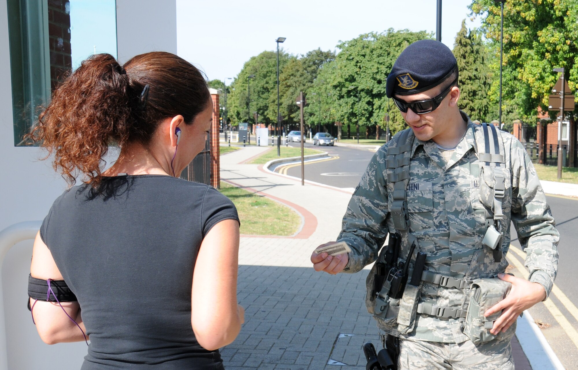 U.S. Air Force Airman 1st Class Joseph Marchini, right, 100th Security Forces Squadron response force leader from East Lyme, Conn., performs a visual check of the photograph on a common access card of a Team Mildenhall member Aug. 4, 2014, on RAF Mildenhall, England. Marchini was making sure the woman is carrying her own CAC.  Every person, military or civilian, must carry a CAC with them at all times while on base. (U.S. Air Force photo/Gina Randall/Released)