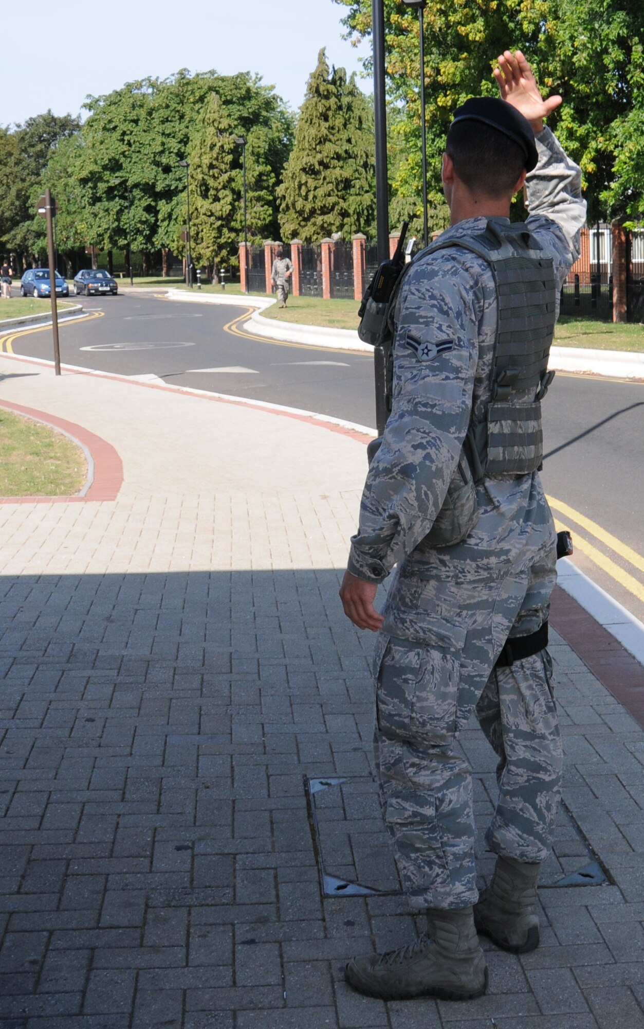U.S. Air Force Airman 1st Class Tyler Reich, 100th Security Forces Squadron response force leader from Boston, directs traffic to exit the base Aug. 4, 2014, on RAF Mildenhall, England. Patrolmen from 100th SFS direct traffic to keep it flowing and ensure the safety of road users. (U.S. Air Force photo/Gina Randall/Released)