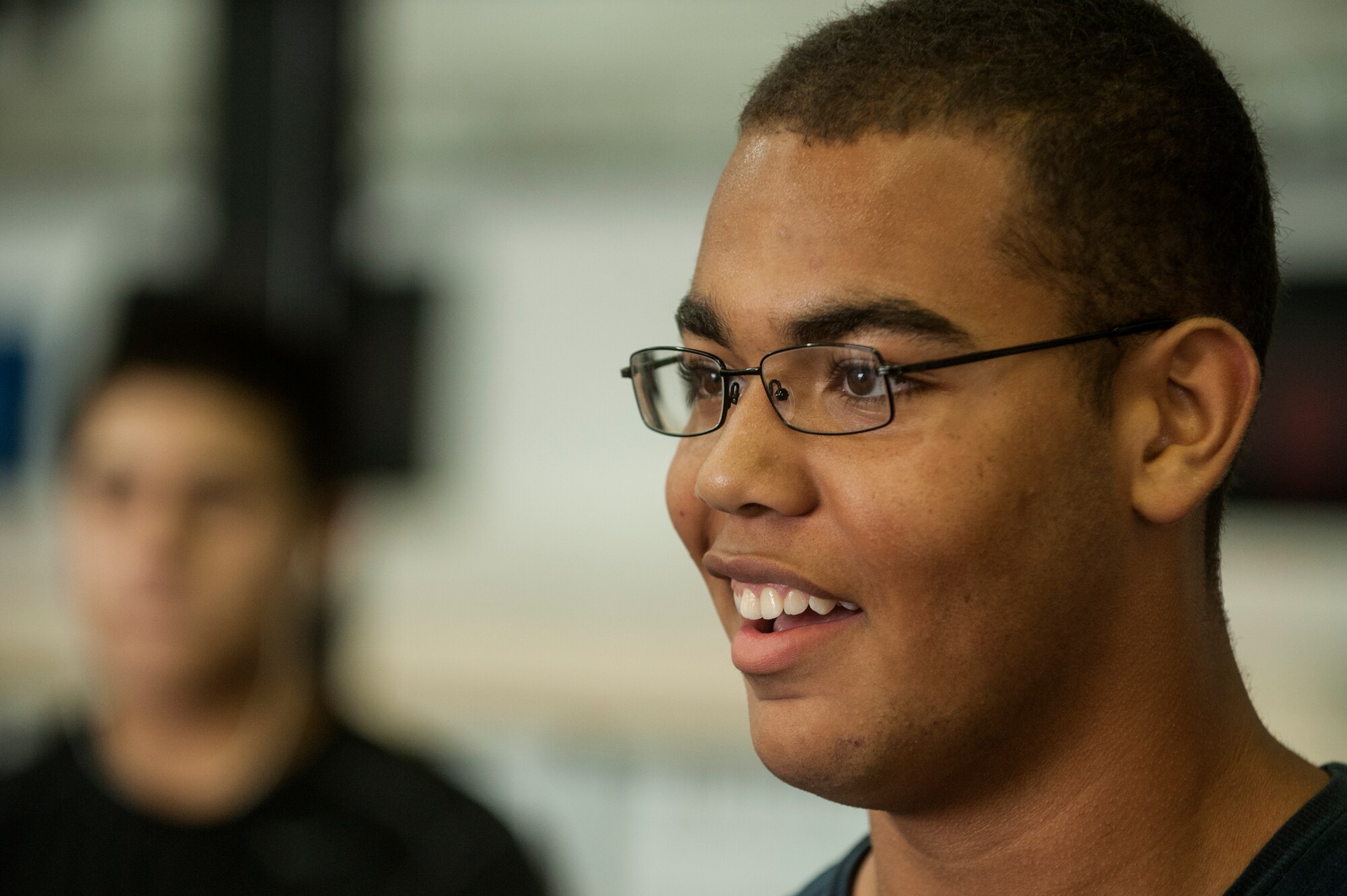 Shane Stitt, son of U.S. Air Force Master Sgt. Jermaine Stitt, 726th Air Mobility Squadron passenger terminal superintendent, smiles during a Bitburg High School summer strength training session Aug. 8, 2014, at Spangdahlem Air Base, Germany. More than 20 students attended each training session throughout the summer. (U.S. Air Force photo by Senior Airman Rusty Frank/Released)