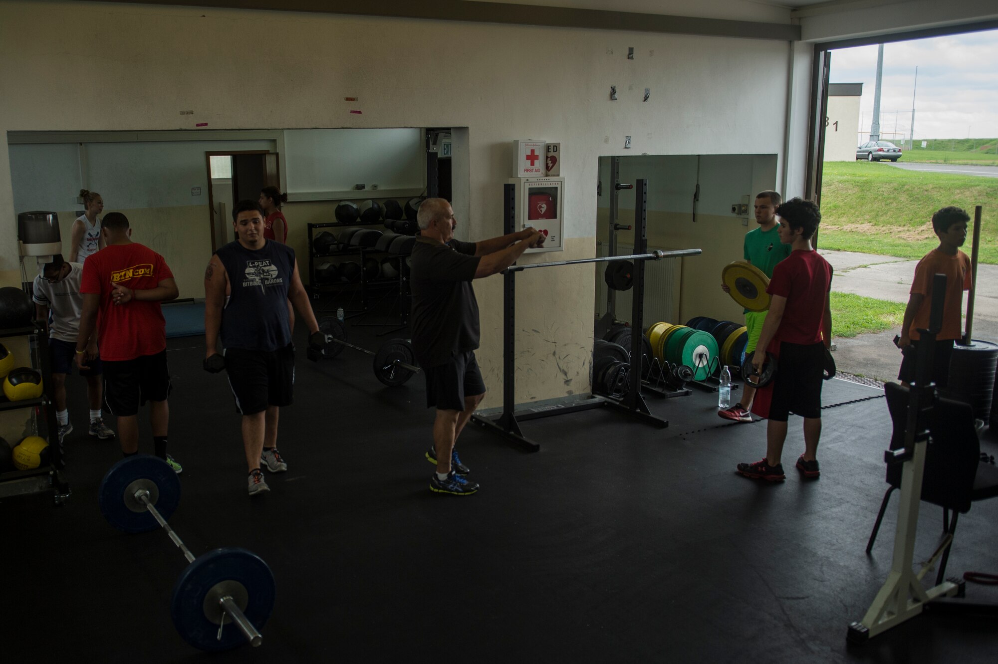 Mike Laue, a Bitburg High School teacher and head coach of the Bitburg High School Barons football team, mentors students during a Bitburg High School summer strength training session Aug. 8, 2014, at Spangdahlem Air Base, Germany. The sessions were open to the entire student body to help students stay in shape during the summer. (U.S. Air Force photo by Senior Airman Rusty Frank/Released)