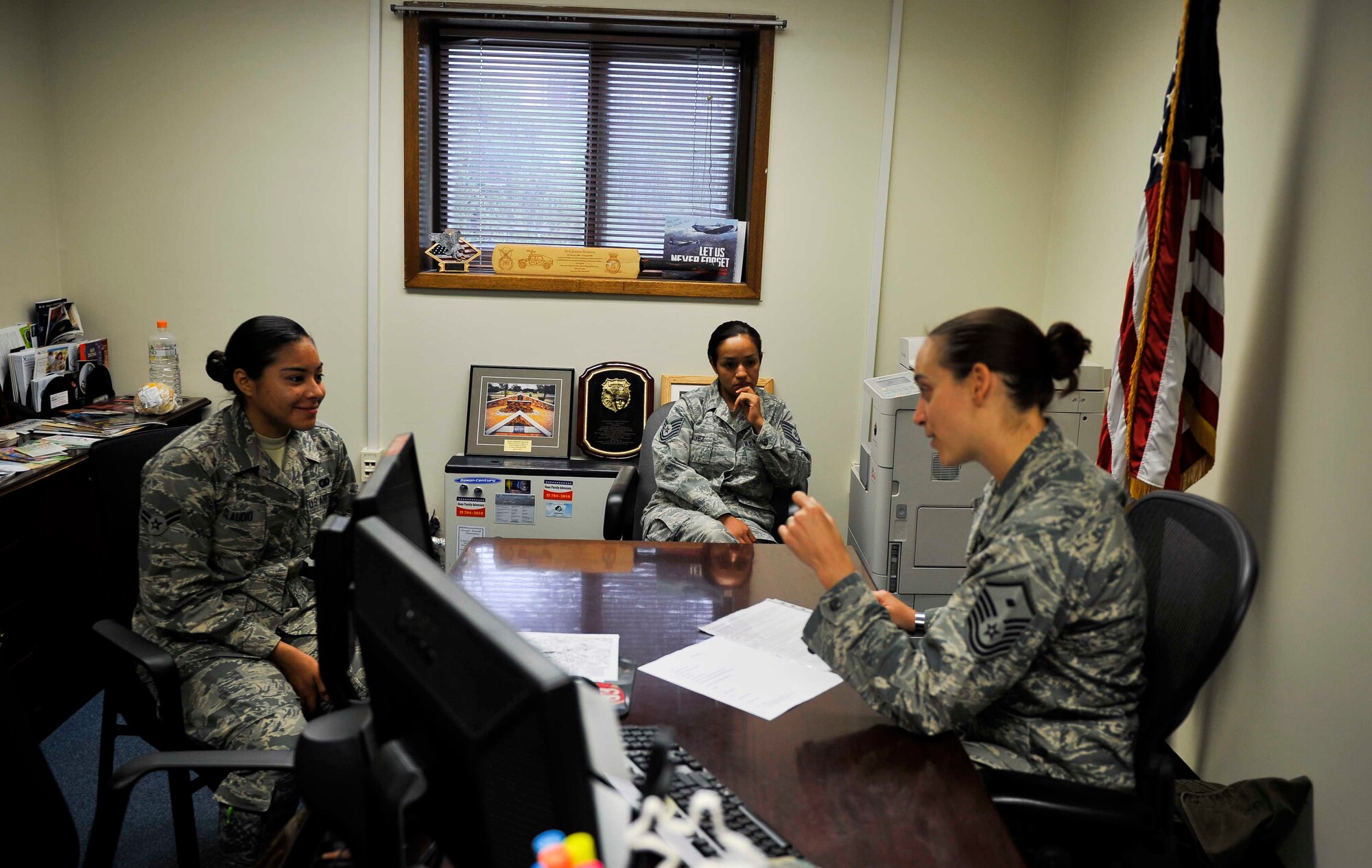 Tech. Sgt. Alejandra Chavez, 51st Fighter Wing Equal Opportunity NCO in charge, listens to Master Sgt. Jessica McWain, 51st FW Staff Agencies and Comptroller Squadron first sergeant, as she talks to an Airman during an initial in-processing brief on Osan Air Base, Republic of Korea, Aug. 7, 2014. McWain decided to implement “Shadow a Shirt” after having two senior NCOs fill in for her as first sergeant during her time away on mid-tour. (U.S. Air Force photo/Senior Airman David Owsianka)
