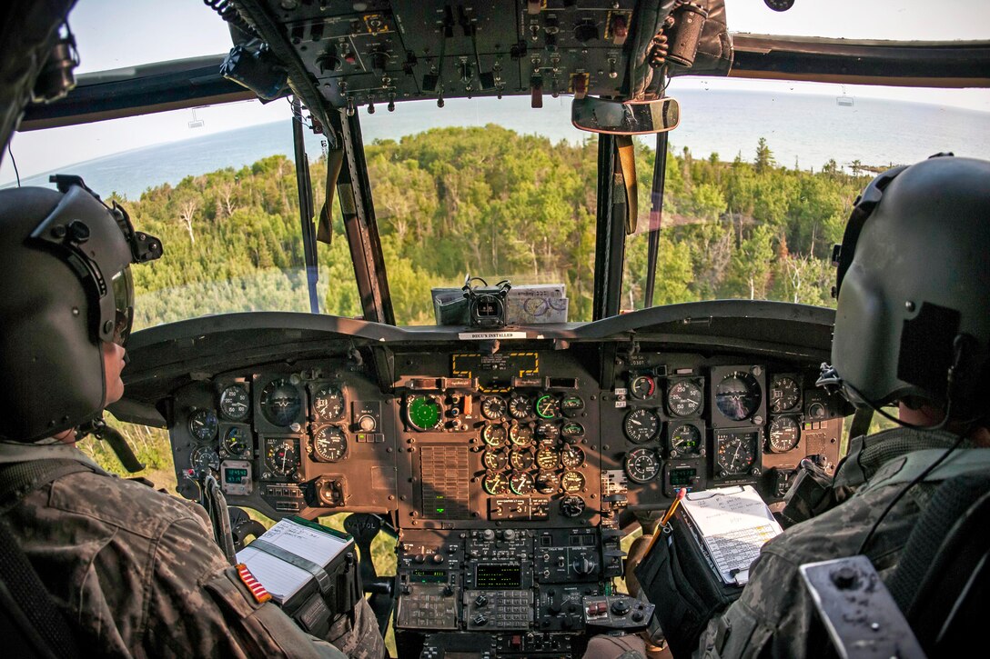 Army Chief Warrant Officer 2 Robert Childers, left, and Army Chief Warrant Officer 3 Lucas Bohm fly a CH-47 Chinook helicopter to transport a tactical air control party to a landing zone during Operation Northern Strike near Rogers City, Mich., Aug. 7, 2014. Childers and Bohm are pilots assigned to the Illinois Army National Guard 2nd Battalion, 238th General Support Aviation Regiment.
