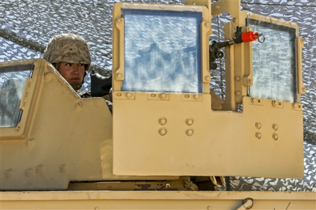 Marine Corps Lance Cpl. Ashley Johnson provides security from atop a Humvee during Large Scale Exercise 2014 on Marine Corps Air Ground Combat Center Twentynine Palms, Calif., Aug. 6, 2014. The exercise trains Marines in the command and control of an expeditionary brigade-sized element operating to support combat, crisis or contingency operations ashore. Johnson is a signals intelligence analyst with the 1st Radio Battalion. 