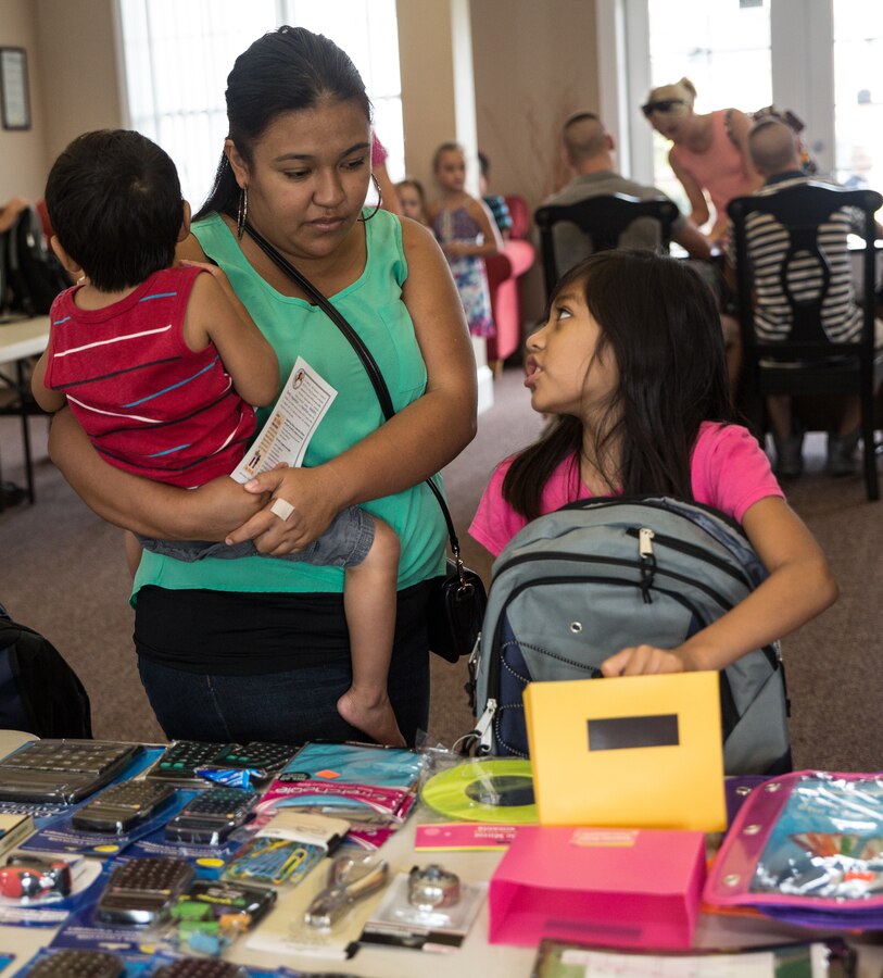 Marlen Martinez helps her daughter, Aileen Canete, pick out essential school supplies Aug. 12, 2014, on Parris Island, S.C. Operation Homefront helped equip Marines’ and sailors’ children for the upcoming school year by distributing school supplies. Only service members ranked E1 to E6 were eligible to register online and receive care packages for children in kindergarten through 12th grade. “[Operation Homefront] has helped us financially and helped us save money,” said Martinez.  (Photo by Cpl. David Bessey) 
