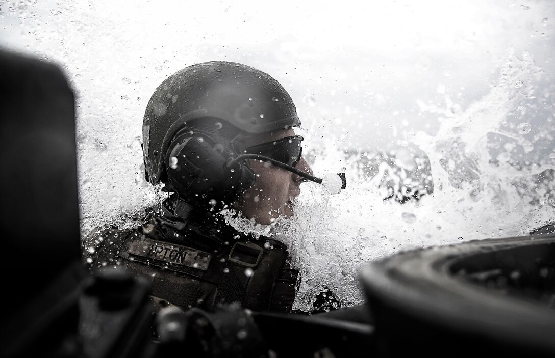 Lance Cpl. Garrick R. Upton, an Amphibious Assault Vehicle operator with 2nd Assault Amphibian Battalion, 2nd Marine Division, shouts a warning back to his crew as he splashes into the surf of the Atlantic Ocean in an AAV aboard Marine Corps Base Camp Lejeune, North Carolina, July 31, 2014. 2nd AABn joined with 2nd Battalion, 10th Marine Regiment, 2nd Marine Division to conduct a training mission to transport the Expeditionary Fire Support System, which is an Internally Transportable-Strike vehicle towing the 120mm mortar, during aerial and amphibious insertions. 

