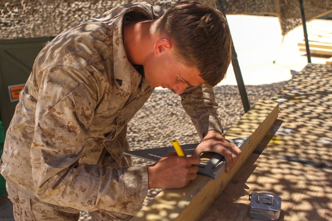 Corporal Tanner Lechner, a combat engineer with Combat Service Support Company, 1st Brigade Headquarters Group, 1st Marine Expeditionary Brigade, makes measurements on a 4”x4” piece of wood to create a ‘gear tree’ during Large Scale Exercise 2014 aboard Marine Corps Air Ground Combat Center Twentynine Palms, Calif., Aug. 4, 2014. A gear tree is a construction made for storing body armor and a Kevlar helmet. LSE-14 is a bilateral training exercise being conducted by 1st MEB to build U.S. and Canadian forces’ joint capabilities through live, simulated, and constructive military training activities from Aug. 8-14. (U.S. Marine Corps photo by Lance Cpl. Angel Serna/Released)

