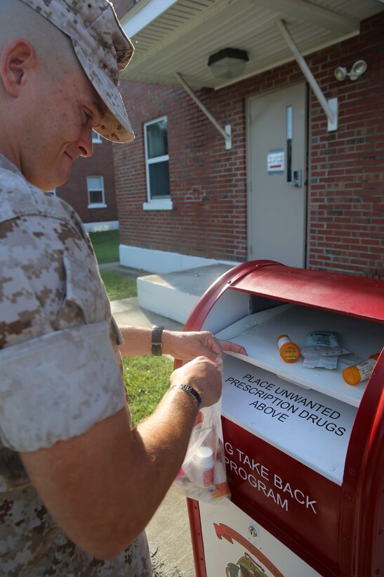 Master Gunnery Sgt. Phillip K. Frazier, the operations chief for 2nd Law Enforcement Battalion, II Marine Expeditionary Force, safely disposes of expired medications during a Mobile Prescription Drug Take Back Program August 12, 2014. The purpose of the program, which was started on July 21, 2014, by 2nd LE Bn. and the Provost Marshall's Office, is to provide a safe, convenient and responsible means of anonymously disposing of prescription drugs. Marines with 2nd LE Bn. set up a red drop-box outside barracks and work areas around Camp Lejeune, where Marines, sailors, and civilians could conveniently dispose of prescription drugs. A permanent dug drop-box, where Marines and other Camp Lejeune personnel can properly dispose of expired of unneeded medication, is located at PMO aboard Camp Lejeune. 