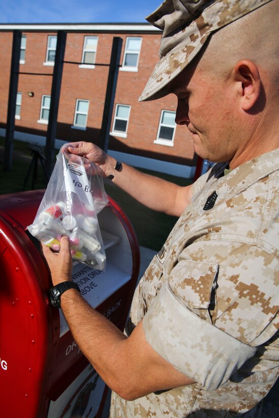 Master Gunnery Sgt. Phillip K. Frazier, the operations chief for 2nd Law Enforcement Battalion, II Marine Expeditionary Force, safely disposes of expired medications during a Mobile Prescription Drug Take Back Program August 12, 2014. The purpose of the program, which was started on July 21, 2014, by 2nd LE Bn. and the Provost Marshall's Office, is to provide a safe, convenient and responsible means of anonymously disposing of prescription drugs. Marines with 2nd LE Bn. set up a red drop-box outside barracks and work areas around Camp Lejeune, where Marines, sailors, and civilians could conveniently dispose of prescription drugs. A permanent dug drop-box, where Marines and other Camp Lejeune personnel can properly dispose of expired of unneeded medication, is located at PMO aboard Camp Lejeune. 