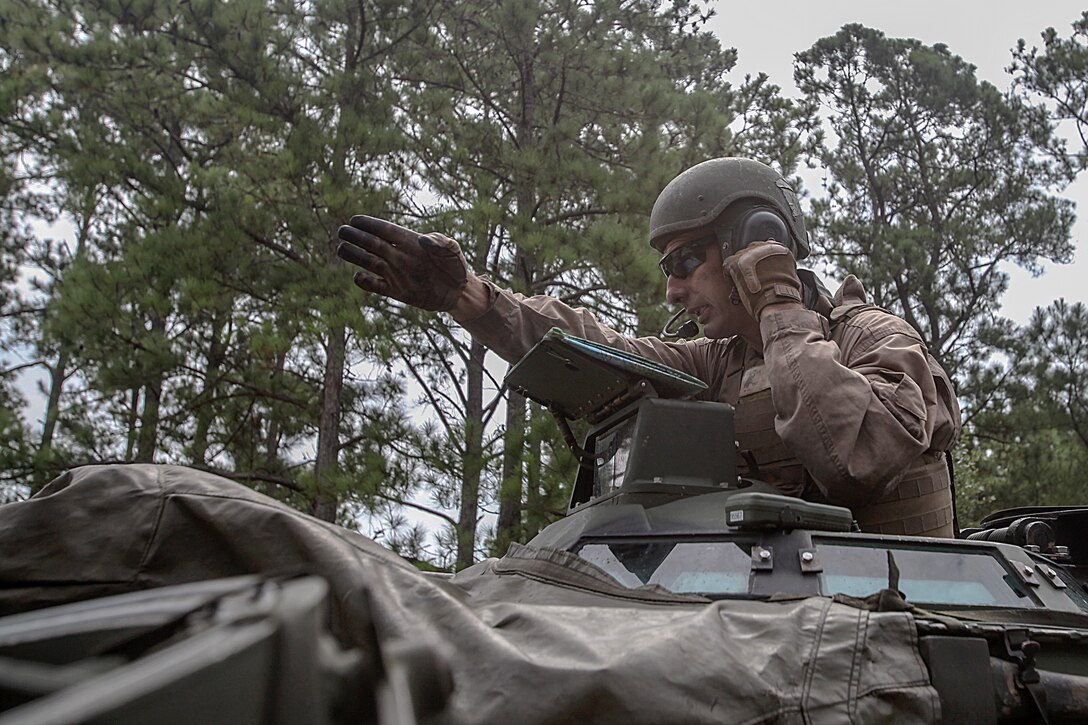 A Marine with 2nd Battalion, 10th Marine Regiment navigates with a map and gives directions to the driver of the Amphibious Assault Vehicle during an amphibious-assault, training mission on Onslow Beach aboard Marine Corps Base Camp Lejeune, North Carolina, July 31, 2014. The mission consisted of transporting the Expeditionary Fire Support System inside the AAV’s through the ocean, then back on land to a live-fire, mortar position to engage targets. 

