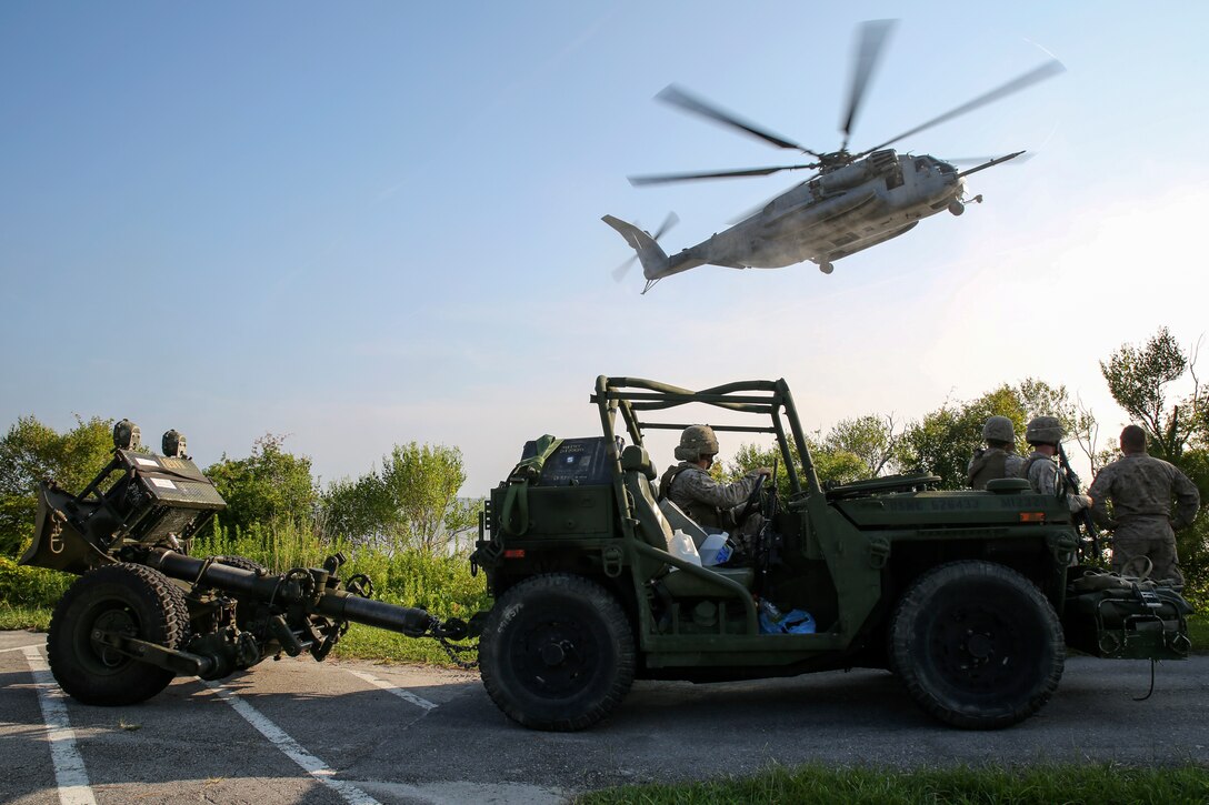 Marines with 2nd Battalion, 10th Marine Regiment, 2nd Marine Division, watch a CH-53E Super Stallion helicopter land while waiting to load their Expeditionary Fire Support Systems to conduct an aerial-raid mission aboard Marine Corps Base Camp Lejeune, North Carolina, July 30, 2014. The EFSS consists of an Internally Transportable-Strike Vehicle with a 120 mm mortar in tow, providing mobile fire support that bridges the gap between 81 mm mortars and the 155 mm cannons. 

