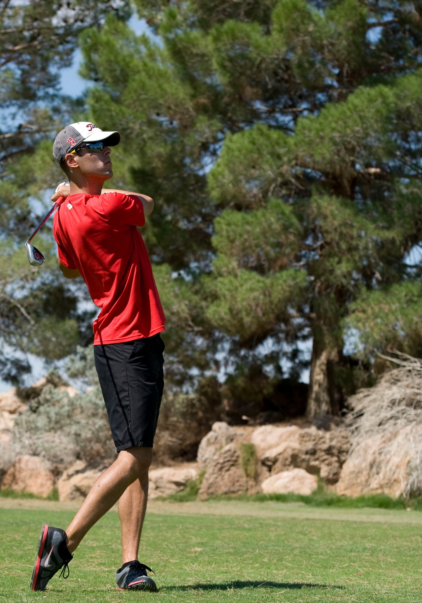 Senior Airman Kevin Carroll, 99th Civil Engineer Squadron power production specialist, hits a golf ball across the course during the 2014 intramural golf championship at Nellis Air Force Base, Nev., Aug. 12, 2014. Carroll and his teammates won the 2014 intramural golf championship during a neck-and-neck match against the 57th Aircraft Maintenance Squadron. (U.S. Air Force photo by Airman 1st Class Mikaley Towle) 