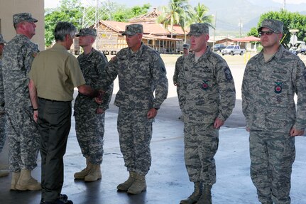 Secretary of the Army John McHugh recognizes U.S. Army 1st Lt. William Tramel, a registered nurse with the Joint Task Force-Bravo Medical Element, for his role in saving two lives during a major vehicle accident response just outside Soto Cano Air Base in a coining ceremony Aug. 13 while in Honduras.  (Photo by Martin Chahin)
