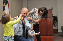 U.S. Air Force Maj. Lee W. Thompson, 145th Logistics Readiness Squadron commander, has his rank boards changed out from Major to Lieutenant Colonel by his daughter Natalie, son Wells and wife Cassie, during his promotion ceremony at the North Carolina Air National Guard base, Charlotte Douglas Intl. airport, August 2, 2014. (U.S. Air National Guard photo by Senior Airman Laura Montgomery, 145th Public Affairs/Released)