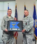 On behave of the officers of the 145th Civil Engineer Squadron, U.S. Air Force Chief Executive Officer, Lt. Col. Timothy E. Moran, presents Lt. Col. Gregory Walters with the squadron guidon in appreciation of his mentoring and leadership after he relinquished his command during a change of command ceremony held at the North Carolina Air National Guard base, Charlotte Douglas Intl. airport, June 7, 2014. (U.S. Air National Guard photo by Master Sgt. Patricia F. Moran, 145th Public Affairs/Released)