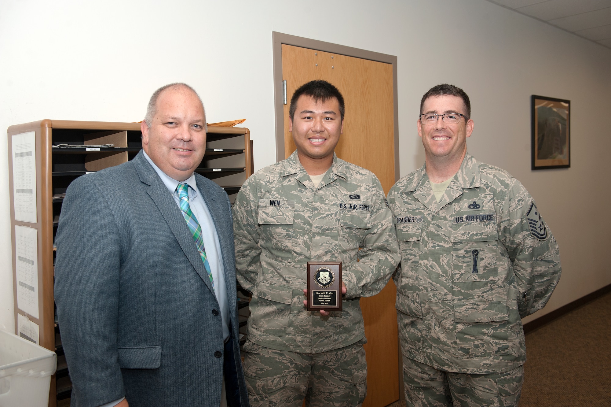 Senior Airman John Wen, 460th Force Support Squadron customer support technician, is awarded the Junior Enlisted of the Month award Aug. 13, 2014, on Buckley Air Force Base, Colo. The JEoM award is given to the most deserving Airmen who have not only shown hard work, leadership and dedication to their job, but also put forth significant effort into bettering themselves and the community. (U.S. Air Force photo by Airman 1st Class Samantha Saulsbury/Released)