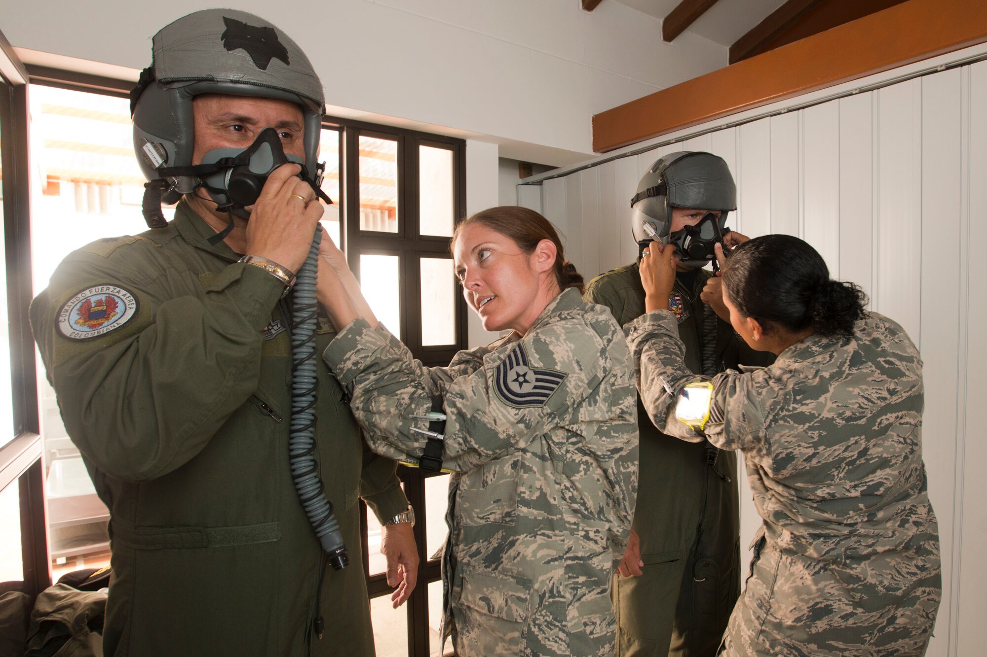 Colombian Air Force Brig. Gen. Carlos Eduardo Bueno and Brig. Gen. Ramses Rueda Rueda (sic) are fitted with flight helmets by U.S. Air Force Tech. Sgt. Hannah Conner and Tech. Sgt. Benita Johnson, both assigned to the 169th Operations Support Squadron's Aircrew Flight Equipment section from McEntire Joint National Guard Base of the South Carolina Air National Guard, Aug. 11, 2014. The fitting is part of the preflight requirements to fly in a SCANG F-16 during Relampago (Lightning) 2014, at Rionegro, Colombia. Relampago is a combined air cooperation engagement with the Republic of Colombia. One hundred Airmen and six F-16s are participating in the first major joint-air training opportunity under the auspices of the South Carolina National Guard's State Partnership Program with the country of Colombia. (U.S. Air National Guard photo by Tech. Sgt. Jorge Intriago/Released)