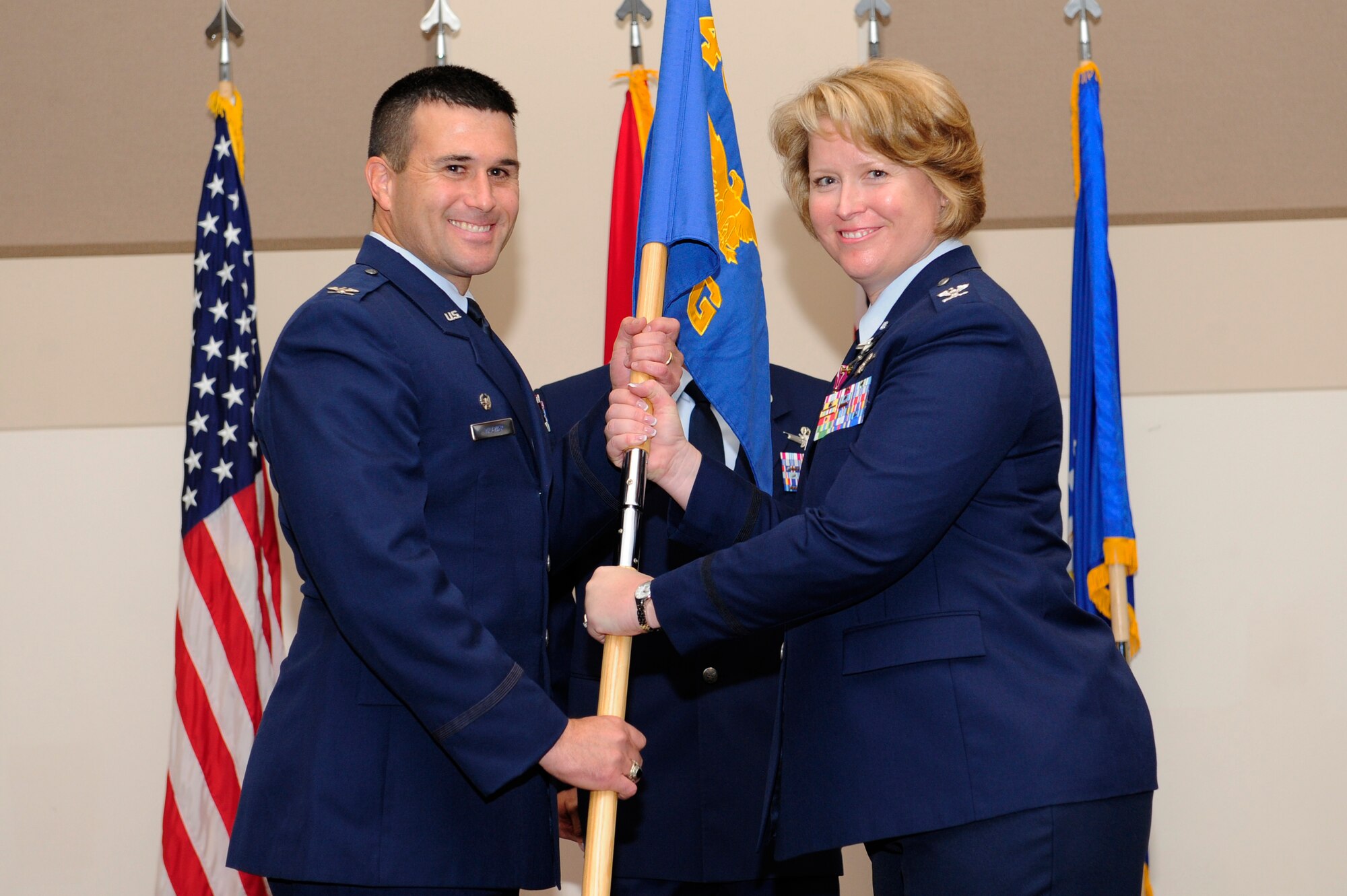 Col. DeAnna Burt, right, relinquishes command of the 460th Operations Group to Col. John Wagner, 460th Space Wing commander, during the 460th OG change of command ceremony Aug. 12, 2014, at the Leadership Development Center on Buckley Air Force Base, Colo. The event signaled Col. Michael Jackson, 460th OG commander, assuming command from Burt, who served as commander of the 460th OG for two years. (U.S. Air Force photo by Airman 1st Class Samantha Saulsbury/Released)