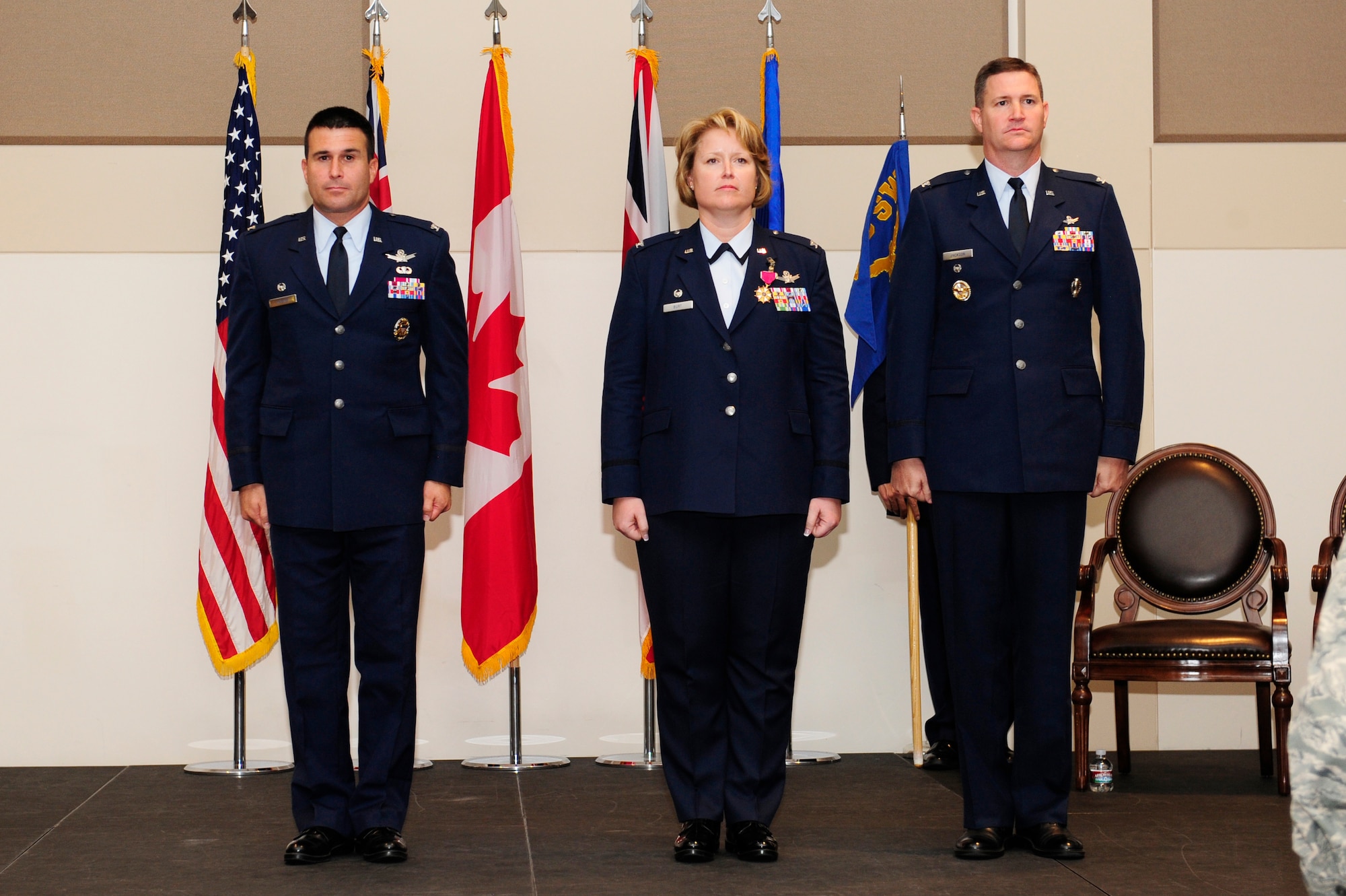 From left, Col. John Wagner, 460th Space Wing commander, Col. Michael Jackson, 460th Operations Group commander and Col. DeAnna Burt, outgoing 460th OG commander, stand at attention during the 460th OG change of command ceremony Aug. 12, 2014, at the Leadership Development Center on Buckley Air Force Base, Colo. Jackson assumed command from Burt, who served as commander of the 460th OG for two years. (U.S. Air Force photo by Airman 1st Class Samantha Saulsbury/Released)