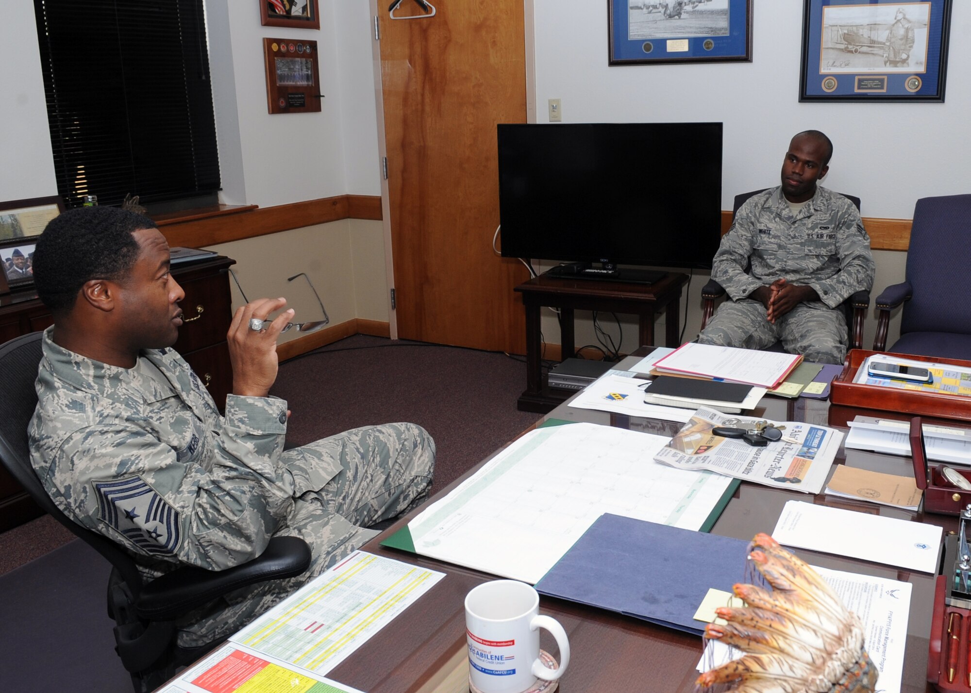 U.S. Air Force Chief Master Sgt. Eddie Webb, 7th Bomb Wing command chief, sits and talks with Senior Airman Ryan White, 7th Component Maintenance Squadron support technician, July 17, 2014, in Webb’s office at Dyess Air Force Base, Texas. As part of Webb’s monthly program, “Thursdays with Chief,” White spent the day shadowing the command chief, and getting to see first-hand a wing staff briefing, luncheon and the command chief’s daily meetings. (U.S. Air Force photo by Airman 1st Class Autumn Velez/Released)