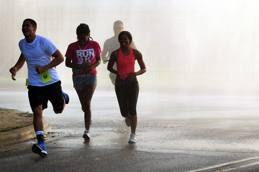 Members of Team Seymour run through water during the Color Me Fab 5K Aug. 13, 2014, at Seymour Johnson Air Force Base, North Carolina. This was the first time Seymour Johnson hosted a color run.  (U.S. Air Force photo/Airman 1st Class Shawna L. Keyes)