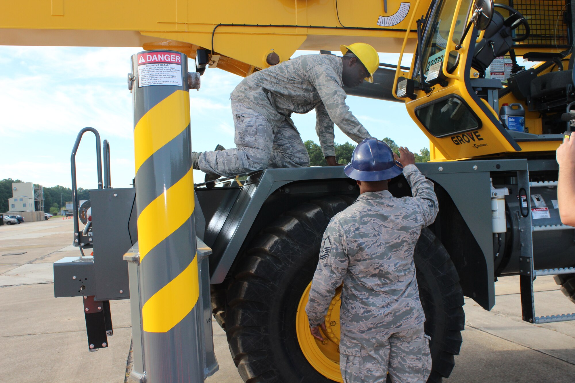 From left, Senior Airman Anthony Burgess, under the guidance of crane operator instructor Master Sgt. Alexes Abrams, works to make sure his crane is level before getting in the cab and beginning operations. Burgess was a student in the crane operator training program offered by the Expeditionary Combat Support-Training Certification Center at Dobbins Air Reserve Base, Ga. The course is taught, along with several other career field courses, on a “dead runway.” (U.S. Air Force Photo/Released)