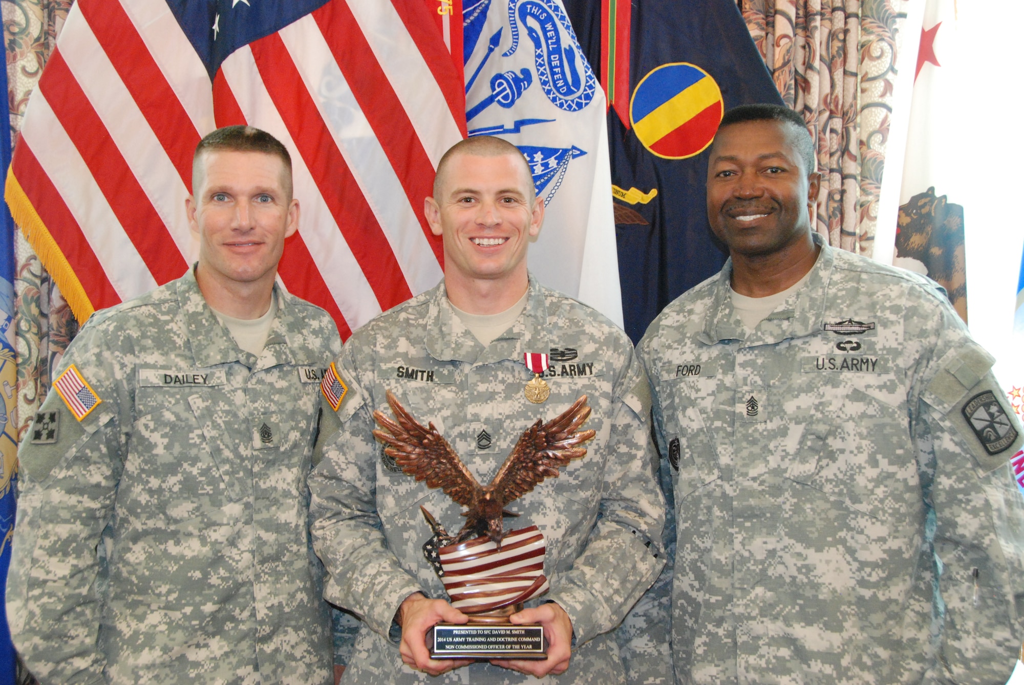U.S. Army Training and Doctrine Command's 2014 Noncommissioned Officer of the Year, Sgt. 1st Class David Smith, representing U.S. Army Cadet Command, Fort Knox, Ky., is recognized by Command Sgts. Maj. Daniel Dailey, TRADOC command sergeant major, and Odell Ford Jr., University of North Georgia's Department of Military Science command sergeant major,  following the competition at Fort Eustis, Va., Aug. 6, 2014. Smith is a military science instructor at the University of North Georgia, 1st Brigade, Cadet Command. (U.S. Army photo by Sgt. 1st Class Lisa Nicolas/Released)