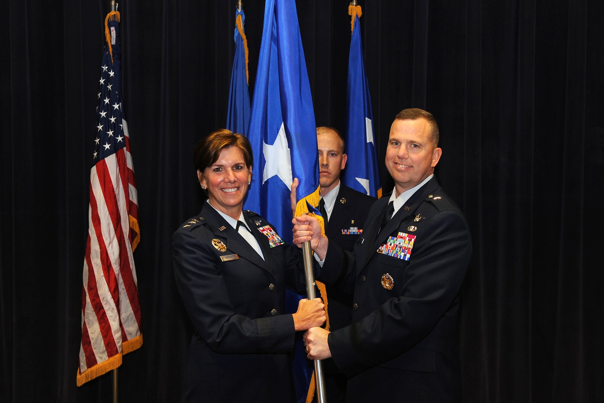 U.S. Air Force Lt. Gen. Lori J. Robinson, vice commander of Air Combat Command, presents U.S. Air Force Brig. Gen. Gregory Guillot, 55th Wing commander, with a one-star flag during his promotion ceremony Aug. 8 at the Air Force Weather Agency Auditorium on Offutt Air Force Base, Neb. Guillot was promoted from colonel to brigadier general during the ceremony with an official pin-on date of Aug. 14. Robinson also toured many Team Offutt facilities during her visit to the base. (U.S. Air Force photo by Josh Plueger/Released)