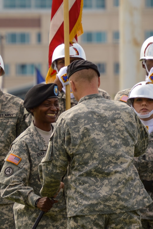 U.S. Army Sgt. Maj. Vickie Culp, 7th Transportation Brigade (Expeditionary) command sergeant major, receives the noncommissioned officers' swords from Col. Randal Nelson, 7th Trans. Bde. (Ex) commander, during a change of responsibility ceremony held at Fort Eustis, Va., Aug. 8, 2014. The passing of the noncommissioned officers' sword signifies a position of responsibility over an entire unit. (U.S. Army photo by Spc. Marian Alleva/Released)