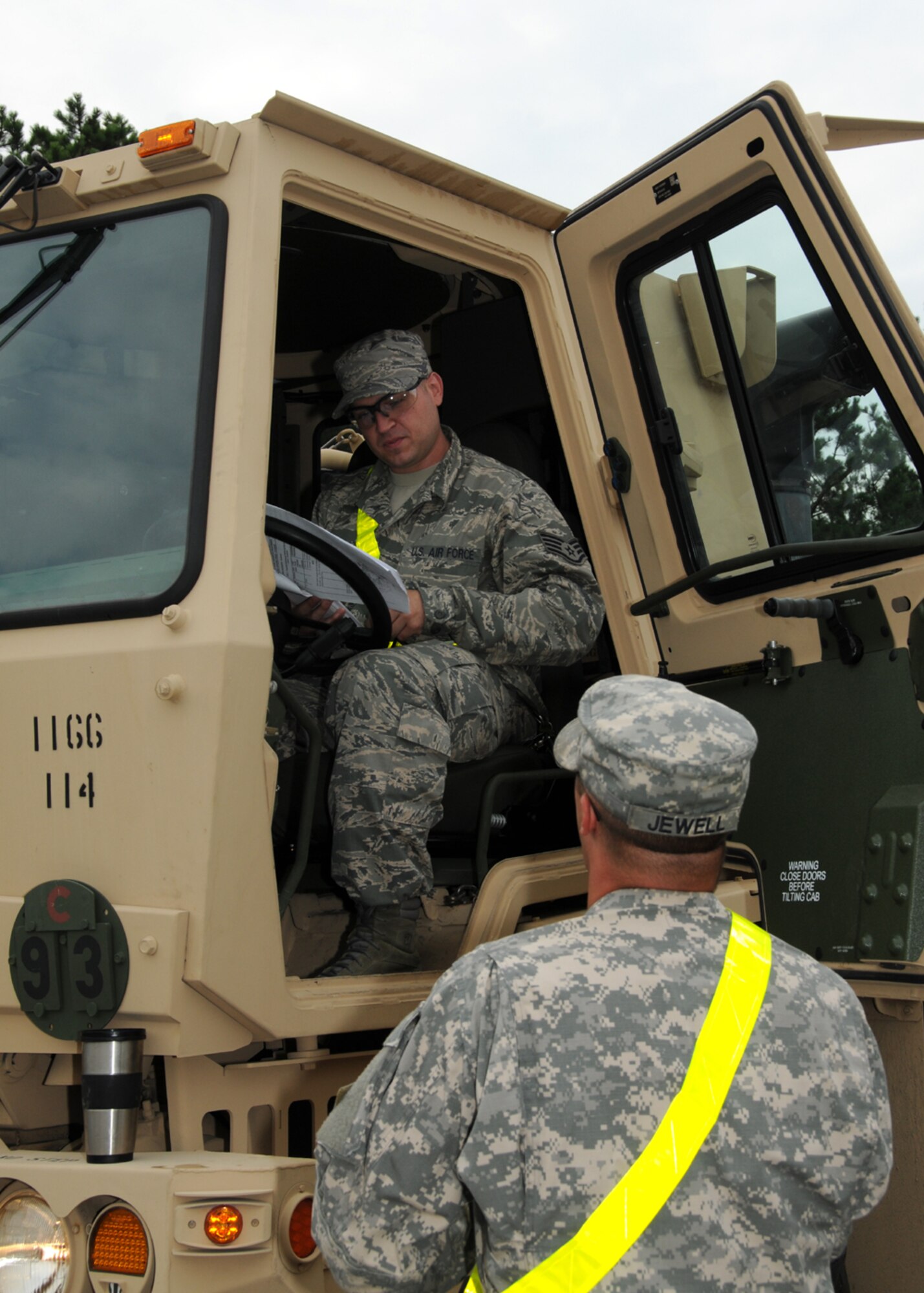 Army Sgt. Jewell oversees Air Force Staff Sgt. Brian Silva performing morning maintenance checks on a light/medium tactical vehicle (LMTV) prior to driving on Aug. 6 here.  Staff Sgt. Silva was the only member from the 267th Combat Communications Squadron to attend the first course taught by the 1166th Transportation Company on the maintenance and operation of the LMTVs.  (U.S. Air National Guard photo by Tech. Sgt. Lindsey Sarah Watson-Kirwin /Released)