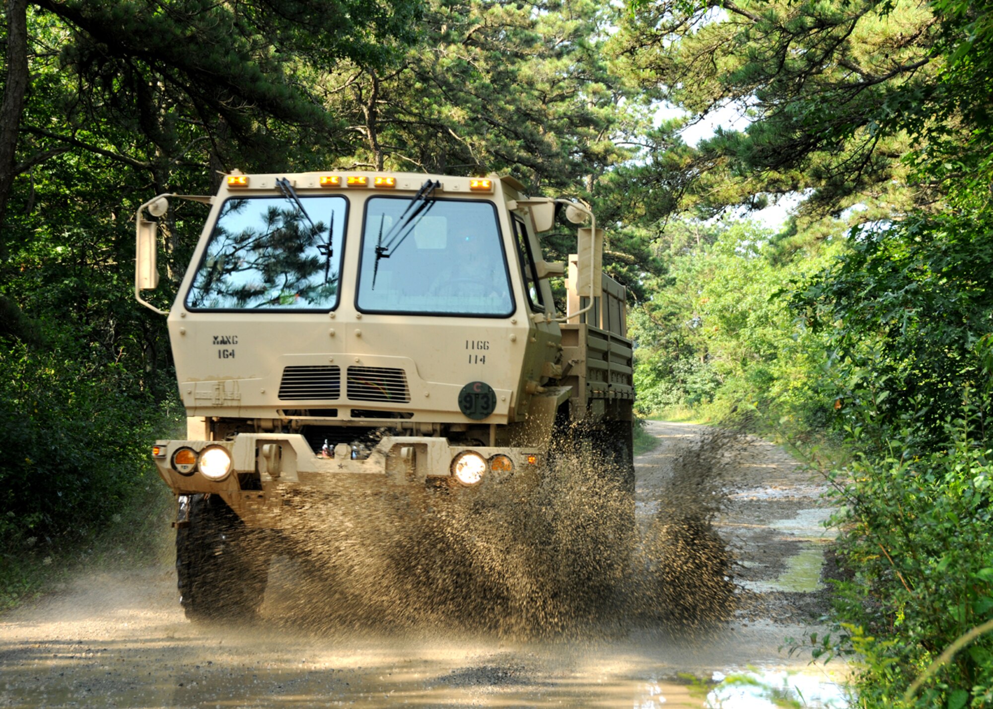 Airmen from the 102nd Intelligence Wing drove through large puddles during reconnaissance for their night-time drive on Aug. 7 as part of their light/medium tactical vehicle training here.  The Airmen drove with a Soldier in the truck with them to provide answer any questions during the drive.  (U.S. Air National Guard photo by Tech. Sgt. Lindsey Sarah Watson-Kirwin /Released)