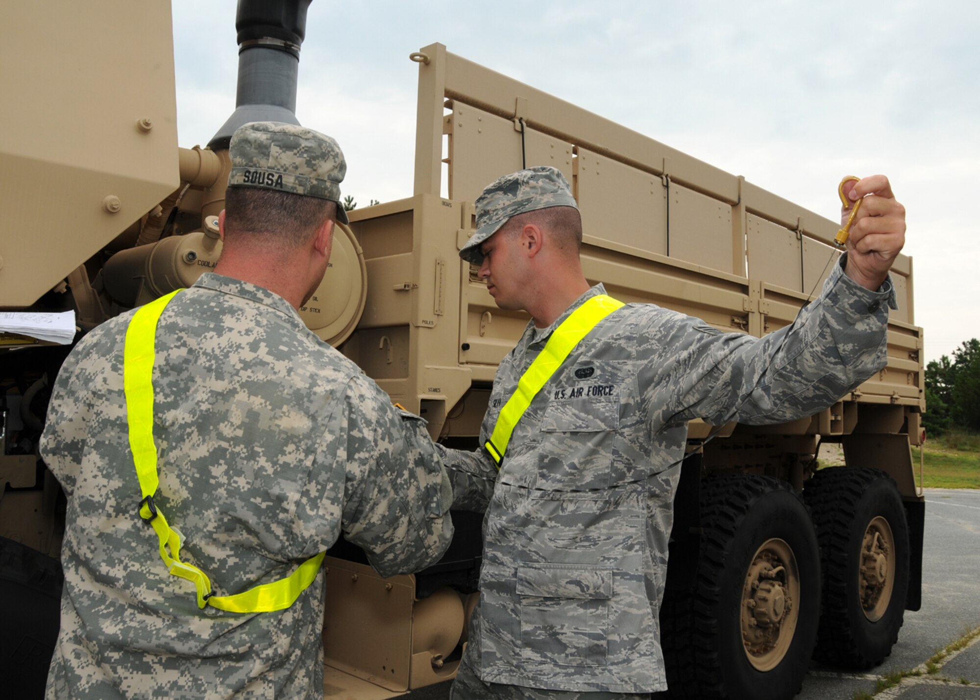 Air Force Staff Sgt. Brian Silva, 267th Combat Communications Squadron, and Army Sgt. Sousa, 1166th Transportation Company, perform maintenance checks on a light/medium tactical vehicle prior to their driving training on Aug. 6 here.  (U.S. Air National Guard photo by Tech. Sgt. Lindsey Sarah Watson-Kirwin /Released)