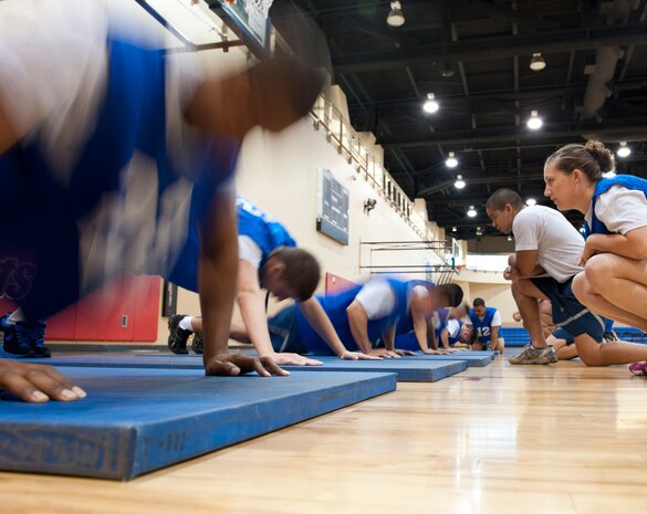 Airmen complete the push-ups portion of the Air Force fitness assessment at the Warrior Fitness Center, Nellis Air Force Base, Nev., Aug. 12, 2014. Airmen have one minute to complete as many push-ups as possible without dropping to their knees, otherwise the portion of the test is terminated and the Airman will not be allowed to continue that section. (U.S. Air Force photo by Airman 1st Class Thomas Spangler)